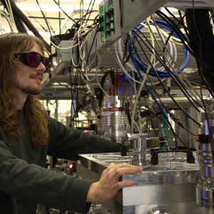 JILA graduate student Nick Jenkins adjusts a setting on his laser tabletop setup. 